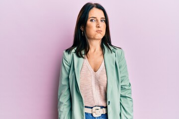 Fototapeta premium Middle age brunette woman wearing casual clothes puffing cheeks with funny face. mouth inflated with air, crazy expression.