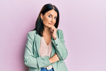 Middle age brunette woman wearing casual clothes with hand on chin thinking about question, pensive expression. smiling with thoughtful face. doubt concept.