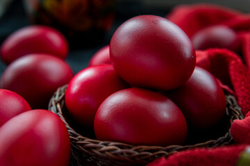 close up of red dyed Easter Eggs in a wicker basket.