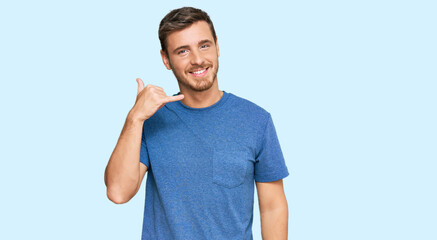 Handsome caucasian man wearing casual clothes smiling doing phone gesture with hand and fingers...