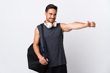 Young sport man with sport bag isolated on white background giving a thumbs up gesture