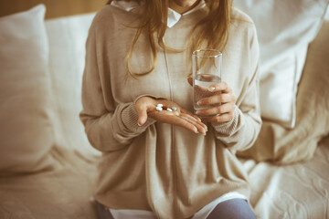 Close-up woman holding pills time to take medications, cure for headache, high blood pressure or...