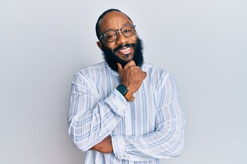 Young african american man wearing business style smiling looking confident at the camera with crossed arms and hand on chin. thinking positive.