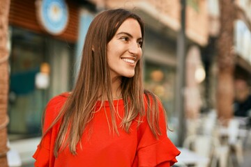 Young hispanic woman smiling happy standing at the city.