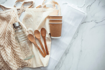Plastic free set with eco cotton bag, glass jar and recycled tableware top view. Zero waste, eco friendly concept. Set of Eco friendly bamboo cutlery, eco bag reusable coffee mug and water bottle.