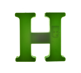 Plastic letter H on magnet isolated on white background, top view