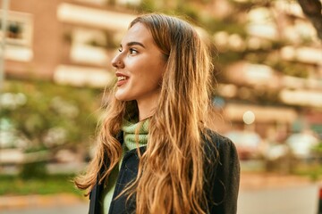Fototapeta premium Young blonde girl smiling happy standing at the city.