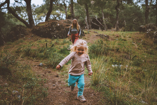 Child girl running in forest family vacations travel lifestyle 2 years old baby walking with mother outdoor happy emotions