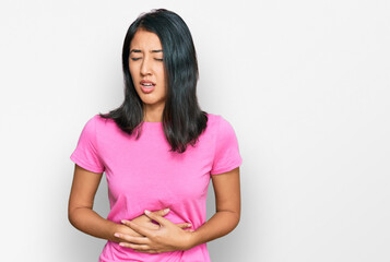 Beautiful asian young woman wearing casual pink t shirt with hand on stomach because nausea, painful disease feeling unwell. ache concept.