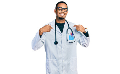 Young african american man wearing doctor uniform and stethoscope looking confident with smile on face, pointing oneself with fingers proud and happy.