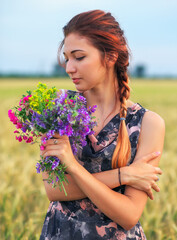 Beauty Girl Outdoors enjoying nature. Beautiful Teenage Model girl in dress on the Spring Field