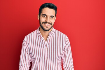 Young hispanic man wearing business shirt looking positive and happy standing and smiling with a confident smile showing teeth