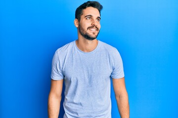 Obraz premium Young hispanic man wearing casual clothes looking to side, relax profile pose with natural face and confident smile.