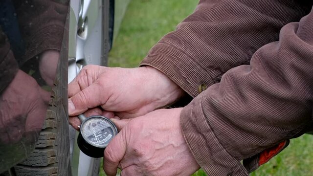 Mechanic Checking Tire Pressure Using Gauge. Mans Hand Holding Tire Gauge Machine For Car Tyre Pressure Measurement. Check Pressure With Tire Gauge Standards And Fill With Air. Vehicle Safety Concept.