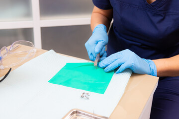 Isolation of the tooth for medical manipulations with a cofferdam. Preparing the rubber dam for use.