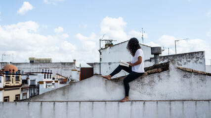 Young woman reading a book in the morning on the roof