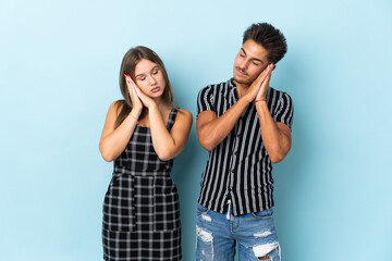 Naklejka premium Teenager caucasian couple isolated on blue background making sleep gesture in dorable expression