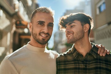 Young gay couple smiling happy and hugging at the city.