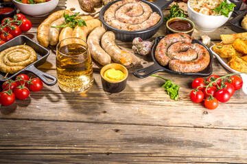 Assortment of different fried sausages. Set with various meat Bavarian, Frankfurt, German grilled sausages, Oktoberfest or summer BBQ party concept, old wooden background copy space top view