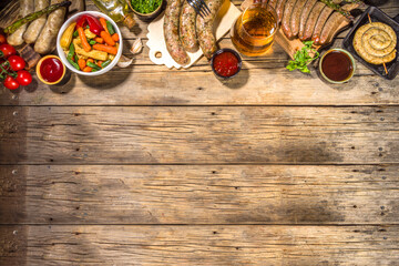 Assortment of different fried sausages. Set with various meat Bavarian, Frankfurt, German grilled sausages, Oktoberfest or summer BBQ party concept, old wooden background copy space top view