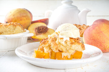 Delicious Summer Peach Cobbler, Homemade sweet summer pie with peaches and vanilla ice cream on white wooden background copy space