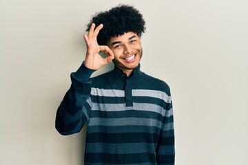 Young african american man with afro hair wearing casual clothes smiling positive doing ok sign with hand and fingers. successful expression.