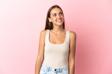 Young woman over isolated pink background thinking an idea while looking up