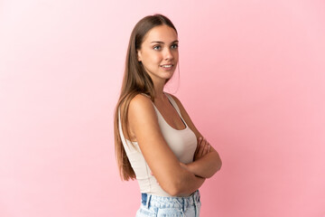 Young woman over isolated pink background looking to the side and smiling