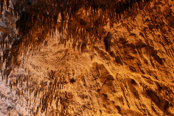 Interior of cave decorated with stalactite. Stone and rock formations in cave. Mineral and crystal formations. Speleology.