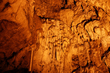 Interior of cave decorated with stalactite. Stone and rock formations in cave. Mineral and crystal formations. Speleology.