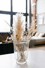 Minimalistic stylish modern Scandinavian decor. Dried flowers in a transparent glass vase in the home interior