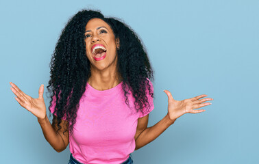 Middle age african american woman wearing casual clothes crazy and mad shouting and yelling with...