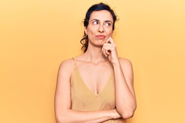 Young beautiful hispanic woman wearing casual clothes serious face thinking about question with...