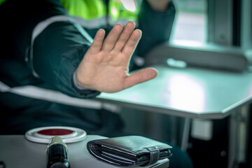 Street lighting. A special car inspector shows a hand gesture. On the table is a wallet and a red...