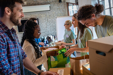 Group of volunteers with working in community charity donation center. - obrazy, fototapety, plakaty