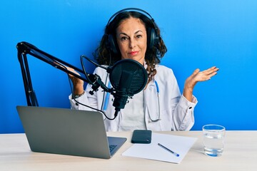 Beautiful middle age doctor woman working at radio studio clueless and confused expression with...
