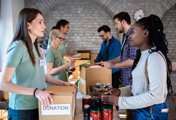 Group of volunteers with working in community charity donation center.