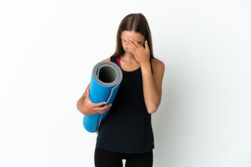 Fototapeta premium Sport woman going to yoga classes while holding a mat over isolated white background with tired and sick expression