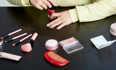 Asian little girl doing makeup on herself in fun