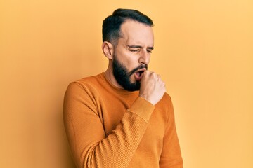 Young man with beard wearing casual winter sweater feeling unwell and coughing as symptom for cold or bronchitis. health care concept.