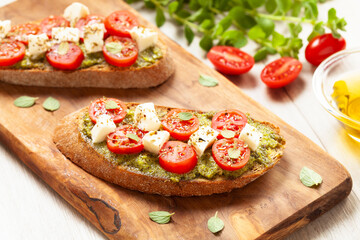 Bruschetta Appetizers with cherry tomatos pesto and mozzarella