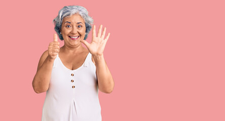 Fototapeta na wymiar Senior woman with gray hair wearing casual clothes showing and pointing up with fingers number six while smiling confident and happy.