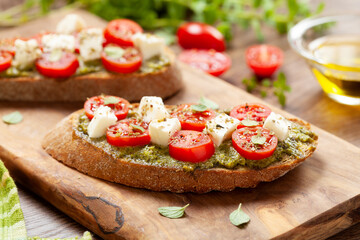 Bruschetta Appetizers with cherry tomatos pesto and mozzarella