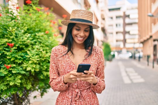 Young african american tourist woman on vacation smiling happy using smartphone at the city.