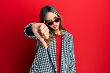 Young brunette woman wearing fashion and modern look looking unhappy and angry showing rejection...