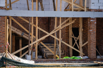 Facade of building made from white blocks with big windows under construction works