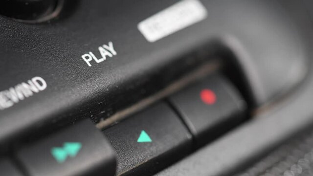 Audio cassette playback. Close-up. Pressing a finger button on an old audio cassette player. Man finger presses the playback control buttons.