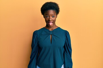 Obraz premium Young african american girl wearing casual clothes sticking tongue out happy with funny expression. emotion concept.