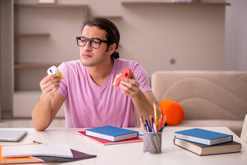 Young male student dentist preparing for exam at home