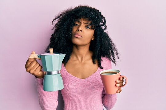 African american woman with afro hair drinking italian coffee skeptic and nervous, frowning upset because of problem. negative person. - Powered by Adobe
